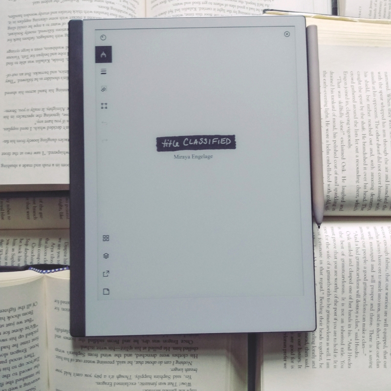 Writing tablet on top of several open books